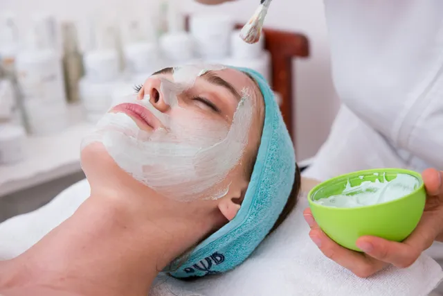 Estetista applica una maschera viso a una cliente in cabina